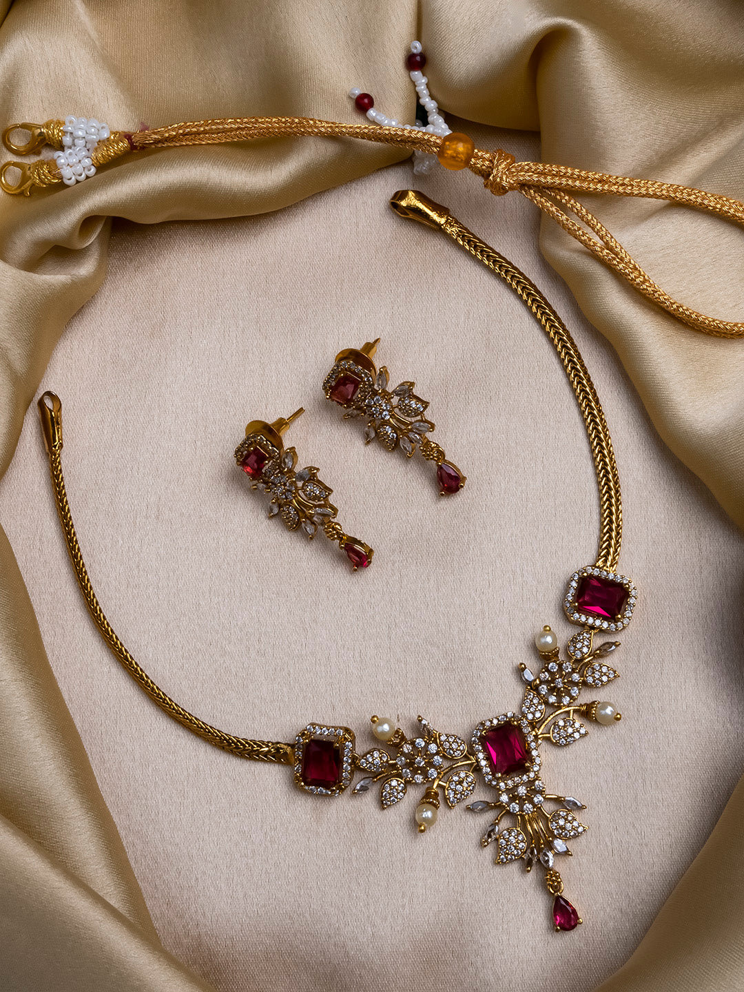 Gold plated red AD stone flower necklace styled with red lehenga