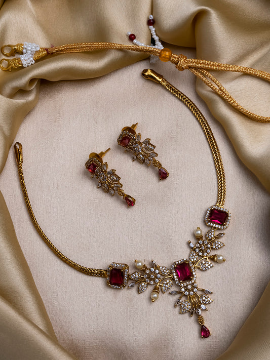 Gold plated red AD stone flower necklace styled with red lehenga