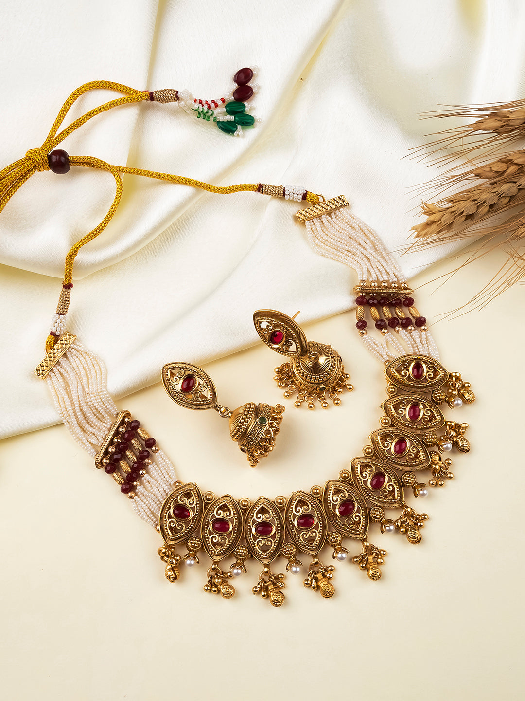 Antique gold kundan necklace set with maroon stones and matching jhumkas
